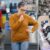 Cliente reflexiva diante de produtos, abordando os fatores do comportamento de consumo.